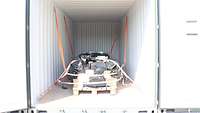 Blick in einen Container mit geöffneten Türen und Zurrgurten