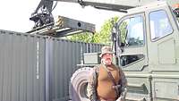 Ein Soldat steht vor einem Container und einem Fahrzeug