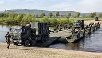Militärfahrzeuge überqueren eine Pionierbrücke