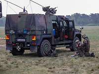 Zwei Soldaten an ihrem Fahrzeug beim Kartenstudium.