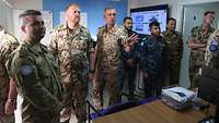 Sieben Soldaten mit verschiedenen Uniformen blicken in die gleiche Richtung. Michael S. steht in der Mitte und erklärt etwas.