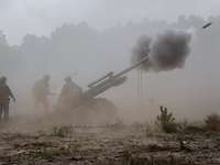 Schlagkräftige belgische Artillerie Im Geschossnebel stehen Soldaten und feuern mit einer Feldhaubitze, aus der ein Geschoss entweicht.