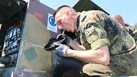 Ein Soldat pustet Staub von einer Dichtung
