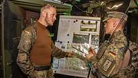 Zwei Soldaten an einer Lagekarte