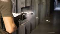 Man firing a weapon at a firing range