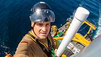 A man works at a great height on an antenna mast