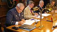 Soldiers and civilians sign documents