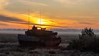 Training mit Kampfpanzern Leopard 2 A7V in der Letzlinger Heide Ein Kampfpanzer in der Morgendämmerung vor einer Buschgruppe