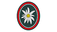 Das dunkelgrüne Wappen ist rot und silbern umrandet, in der Mitte ein Edelweiß mit goldener Rosette.