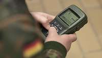 Ein Soldat hält einen GPS-Empfänger in der Hand