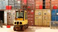 Alte Lagercontainer Vor mehreren aufeinander gestapelten Seecontainern steht ein Gabelstapler