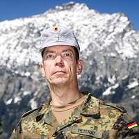 Ein Soldat mit einer grauen Gebirgsmütze schaut freundlich in die Kamera.