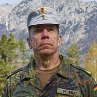 Ein Soldat mit einer grauen Gebirgsmütze schaut freundlich in die Kamera.