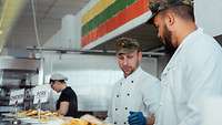 Zwei Soldaten helfen in der Kantine bei der Ausgabe des Mittagessens