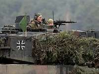 Kompaniechefin Major Karolin Böhme Eine Soldatin mit Funkgerät schaut aus der Dachluke eines Panzers.