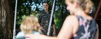 Ein Soldat mit seiner Familie Ein Soldat mit seiner Frau und seinem Kind, das auf einer Schaukel sitzt.