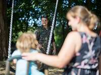 Ein Soldat mit seiner Familie Ein Soldat mit seiner Frau und seinem Kind, das auf einer Schaukel sitzt.