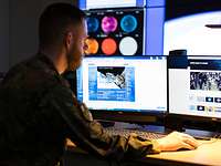 Ein Soldat am Arbeitsplatz im Weltraumlagezentrum in Uedem Ein Soldat sitzt vor mehreren Bildschirmen.