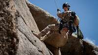Ein mongolischer Soldat seilt sich an einer Felswand ab.