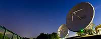 Weltraumbeobachtung Zwei Radaranlagen mit riesigen Satellitenschüssel von unten fotografiert vor einem Sternenhimmel.