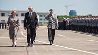 Staatssekretär Benedikt Zimmer schreitet mit einer Frau und einem Soldat die Front angetretener Soldaten ab.