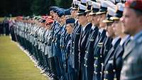 Angetreten zur Beförderung Soldaten stehen in Reih und Glied auf einer Wiese.