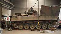 Panzerreparatur in der Werkshalle Soldaten reparieren einen Schützenpanzer Mader in einer Werkshalle.