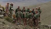 Ein deutsche und mehrere mongolische Soldaten stehen in der Steppe an einem taktischen Sandkasten.