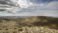 Blick über die mongolische Steppe mit kleinen Bergen