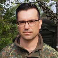 Ein Soldat im Porträt. Im Hintergrund steht ein Wappen mit der Aufschrift „VersBtl 131“.