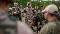 Mongolische Soldatinnen und Soldaten stehen als Gruppe vor einem deutschen Soldaten.