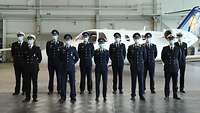 Graduierung Gruppenfoto Die Absolventen stehen vor einem Trainingsflugzeug der Lufthansa.