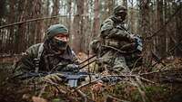 Zwei getarnte Soldaten im Wald. 