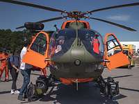 Für jeden was dabei Besucher betrachten einen grün-orangefarben lackierten Hubschrauber.