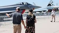 Ein Paar läuft vor zwei Eurofightern im Static Display