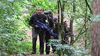 Soldatinnen und Soldaten laufen über ein Feld 