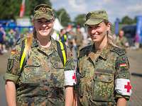 Zwei Soldatinnen vom Sanitätsdienst stehen nebeneinander und lächeln in die Kamera.