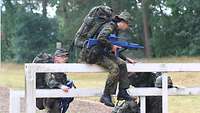 Soldatinnen und Soldaten klettern über Hindernisse