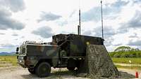 Drei Lastkraftwagen der Bundeswehr mit verschiedenen Aufbauten stehen zusammen 