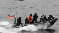 Mehrere slowakische Soldaten fahren auf einem Speedboot.