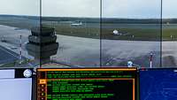 Vier Monitore auf denen ein Flugplatz zu sehen ist 
