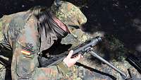 Ein Obergefreiter mit verbundenen Augen baut ein Maschinengewehr 3 zusammen.