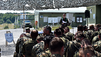 Unter der Leitung eines Militärpfarrers wird im Freien und innerhalb eines Feldlagers ein Feldgottesdienst abgehalten.