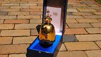 Eine goldene Glocke auf einer Schatulle mit blauer Einlage