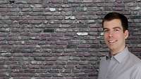 Mann vor einer Wand 