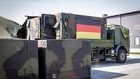 Auf einer Außenfläche stehen zwei LKWs der Bundeswehr, die während der CWIX ihre IT-Systeme testen