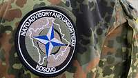 Ein Patch mit der Aufschrift „Nato Advisory and Liaison Team“ sowie „Kosovo“ auf dem Ärmel einer Uniform 