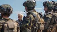 Ministerin Lambrecht steht vor einer Gruppe von Soldaten im Gefechtsanzug.