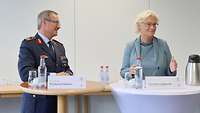 Zwei Personen stehen am Stehtisch.