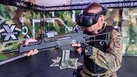 Ein Soldat steht mit VR-Brille und einer Waffenattrappe im Anschlag in einem Übungsraum
